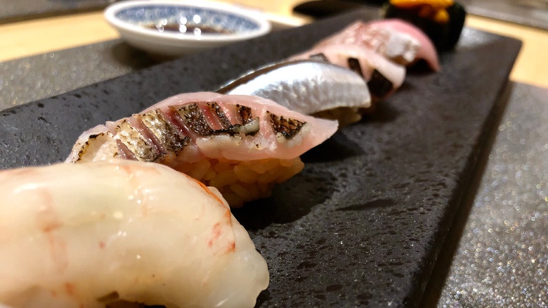 various sushi on black clay plate