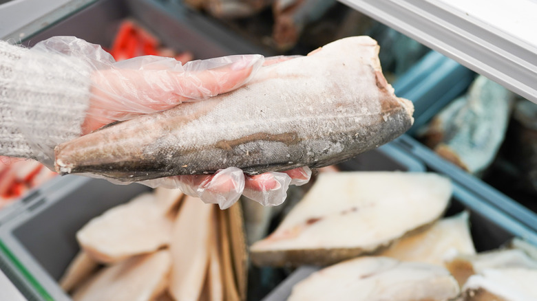 woman selecting frozen fish fillet