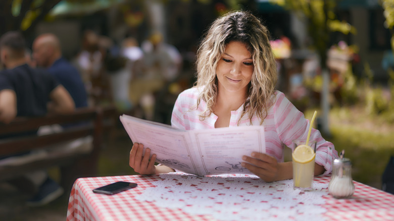 woman reading restaurant menu