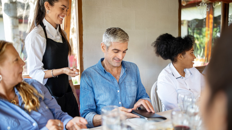 waitress giving man dinner bill