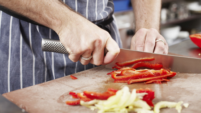 chef cutting red bell pepper