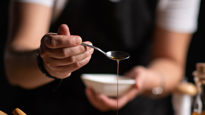 Woman drizzling olive oil