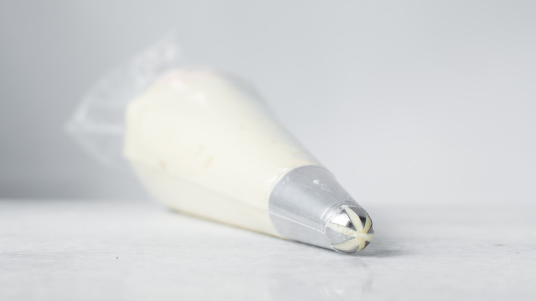 Piping bag with white frosting on a white counter