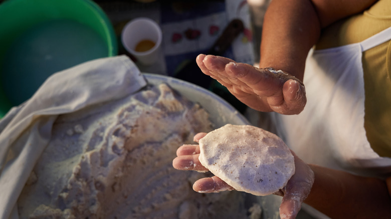 Perosn making corn tortillas hand