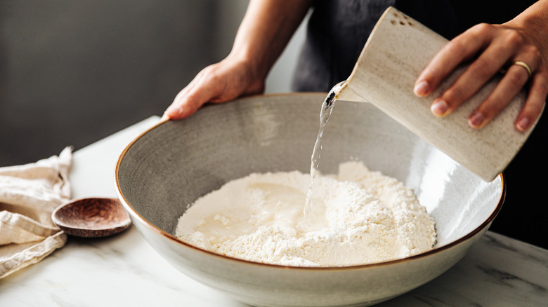 Pouring water into flour bowl