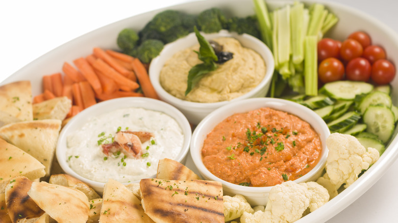 A platter packed with vegetable crudites, dips and pita chips