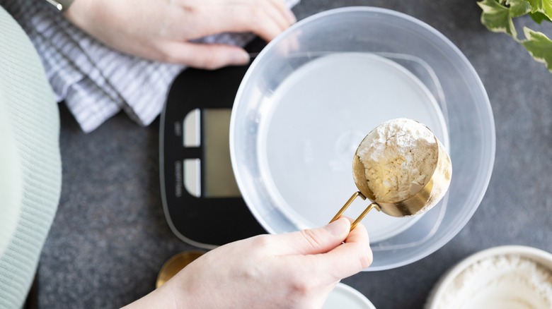 Putting flour into bowl over kitchen scale