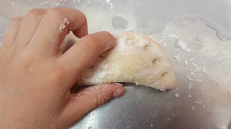 Hand pinching dumpling closed