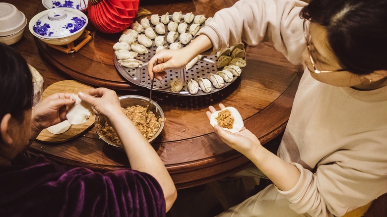 Two women assembling dumplings