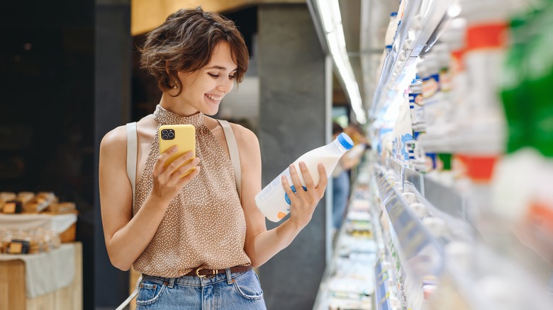 woman selecting milk in grocery store