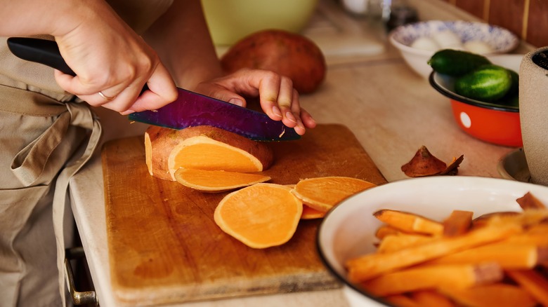 Person slicing sweet potato