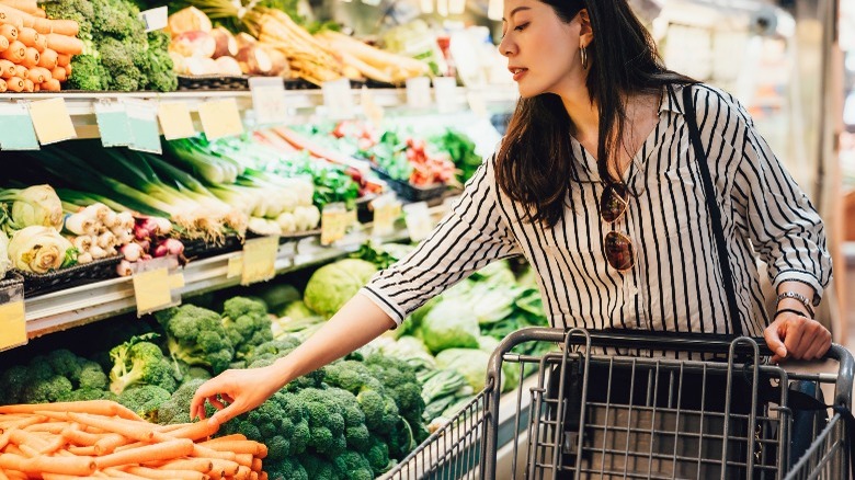 woman buying carrots at supermarket