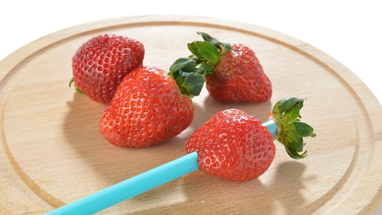 Strawberry with straw through it