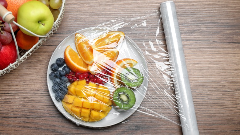 wrapping plate of fruit with plastic wrap