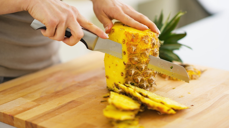 Woman cutting pineapple