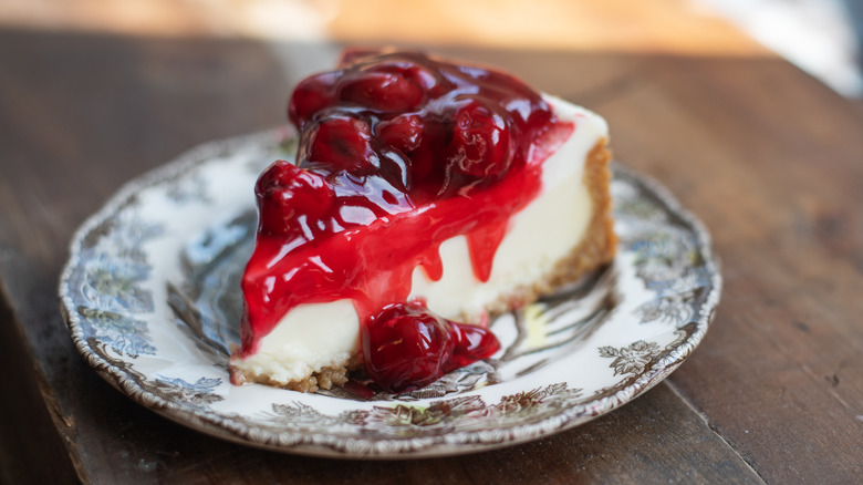 New York cheesecake on plate with cherry sauce