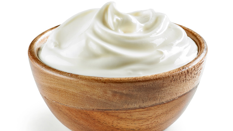 Sour cream in wooden bowl