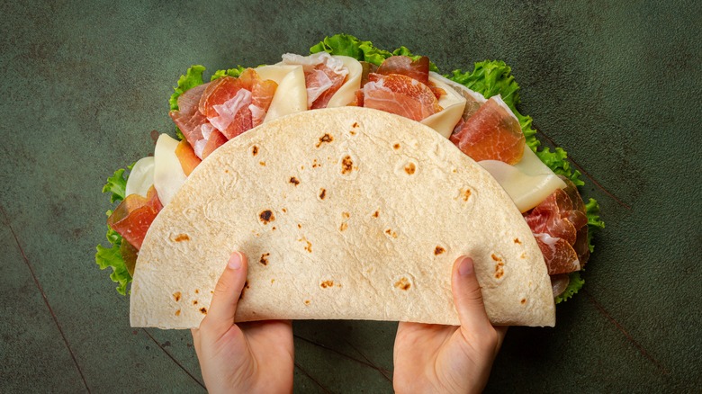 hands holding Italian piadina sandwich