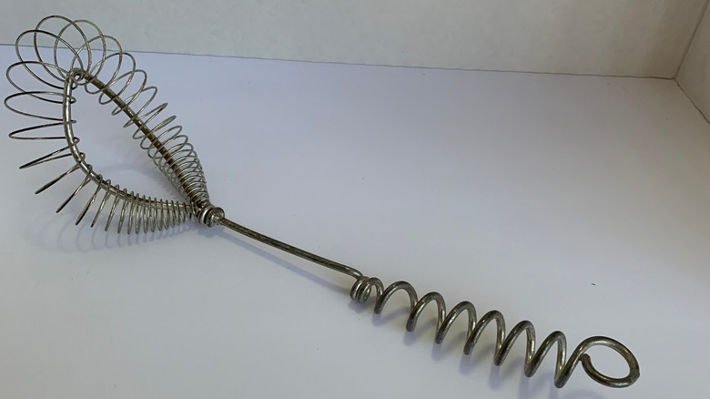 vintage spiral whisk on plain surface