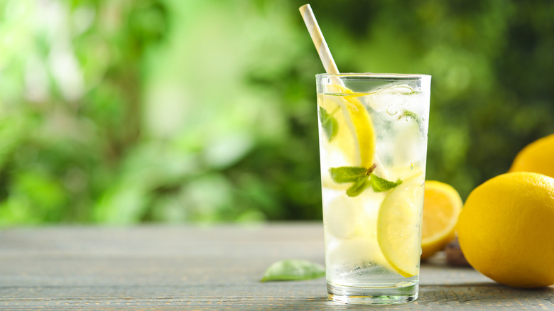 Fresh lemonade and fruits on table