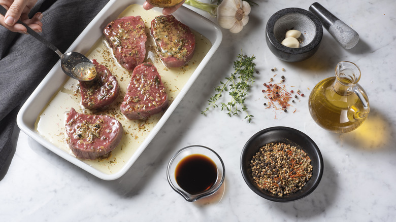 Meat soaking in marinade on table