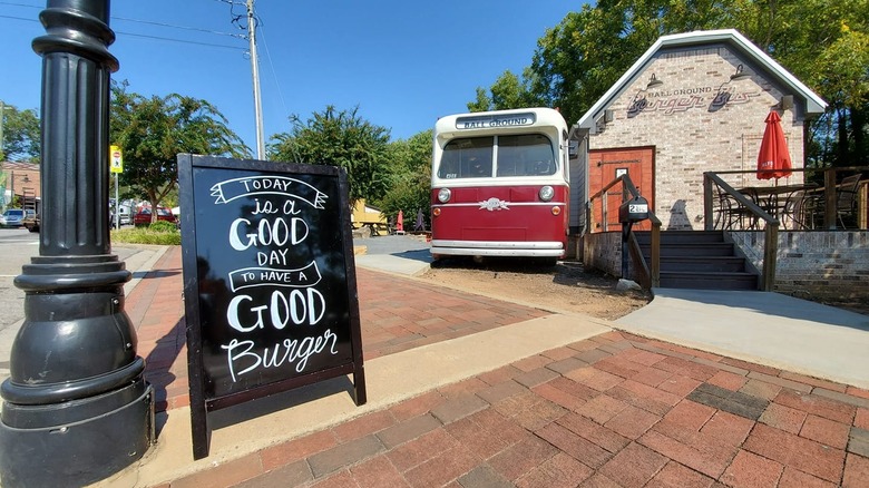 sandwich board sign and red vintage bus