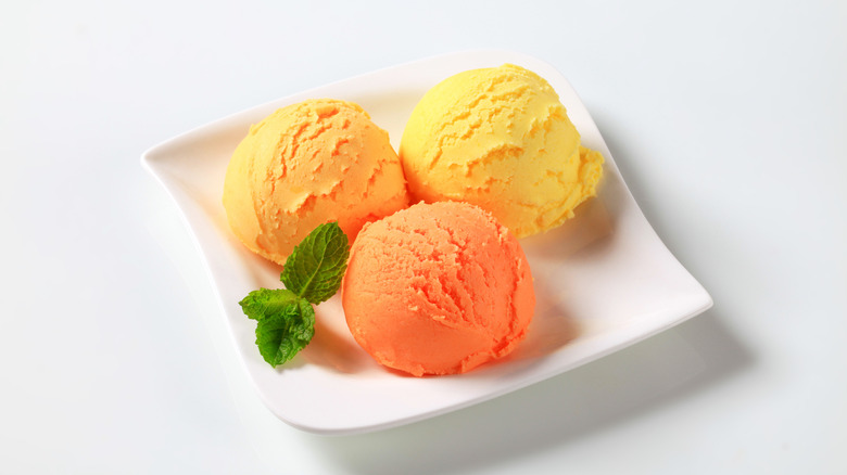 scoops orange sorbet on plate