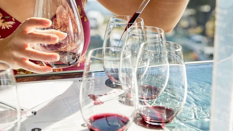 woman pipetting wine into glass