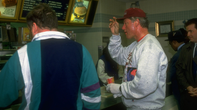 President Clinton in sweats holding a drink at McDonald's after a jog