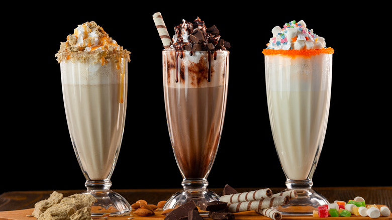 Three milkshakes against black background