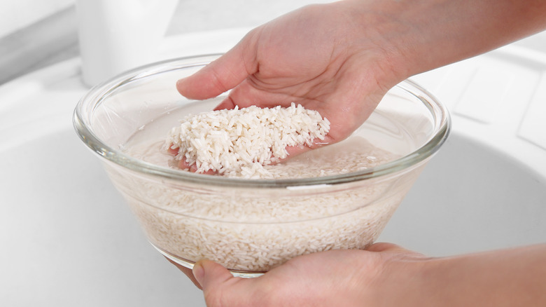 Hand rinsing rice in bowl