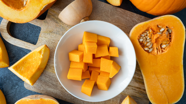 Diced butternut squash in bowl and on kitchen countertop