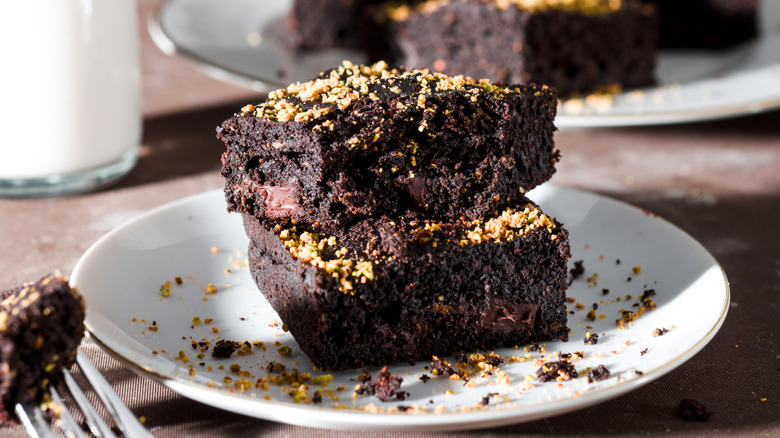 Cauliflower brownies on white plate with glass of milk