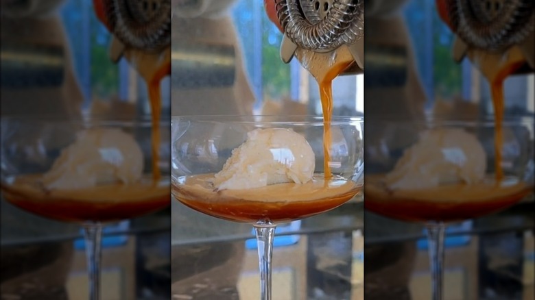 Pouring espresso martini cocktail into a glass with ice cream