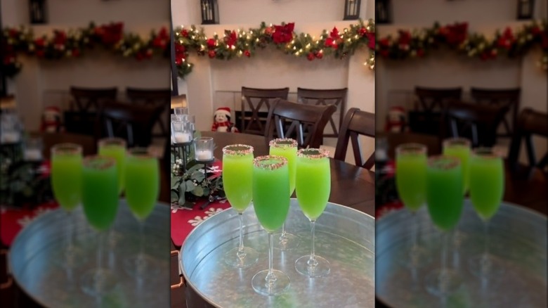 Four green "Grinch" mimosas in champagne flutes