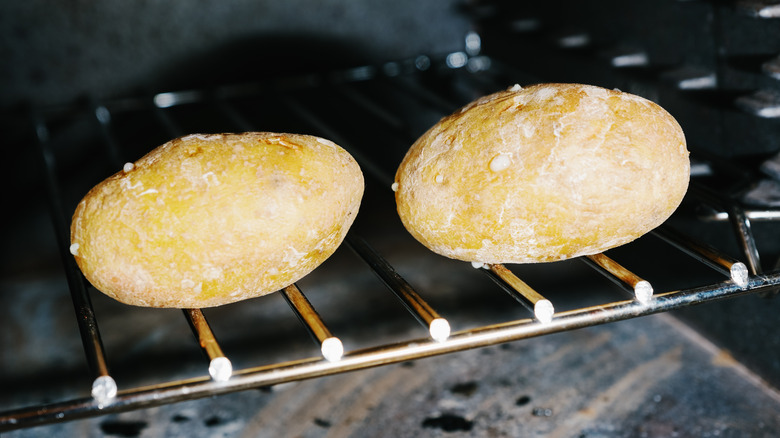 Two potatoes on oven rack