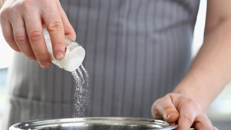 Cook pouring salt into bowl