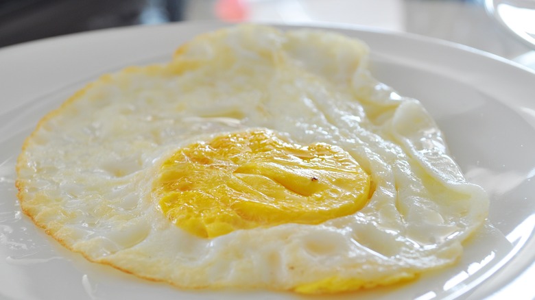 Over-hard egg on white plate