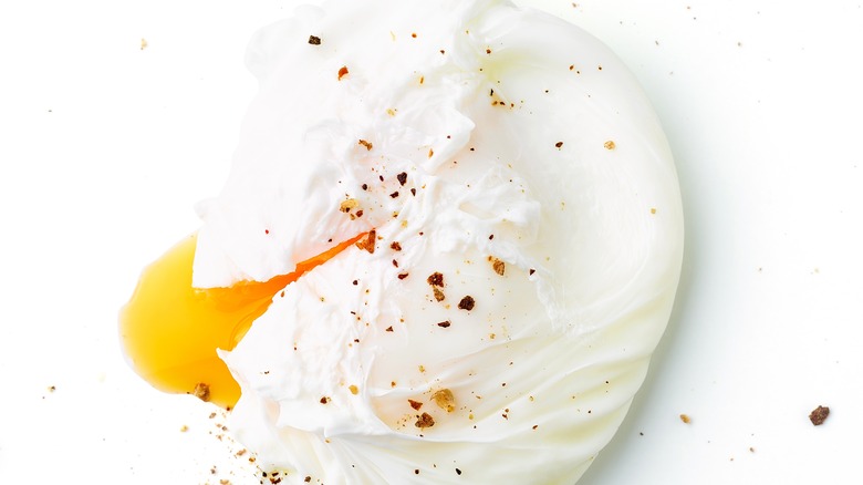 Poached seasoned egg on white background