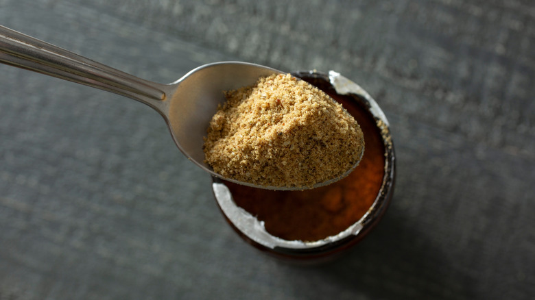 Spoon scooping bouillon powder from jar