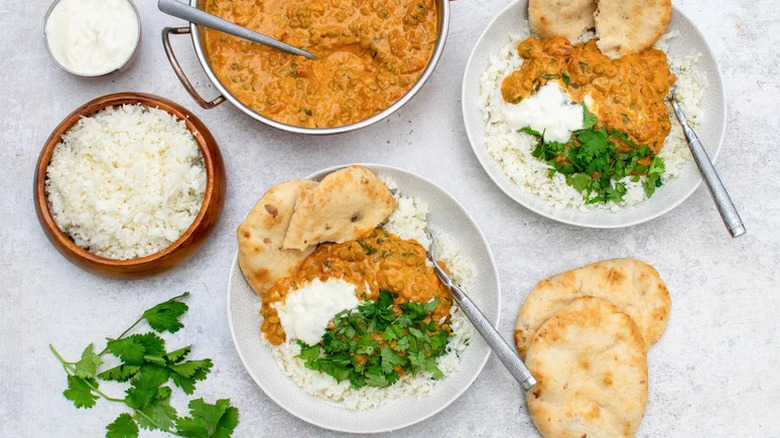 plates of cauliflower rice over lentil curry