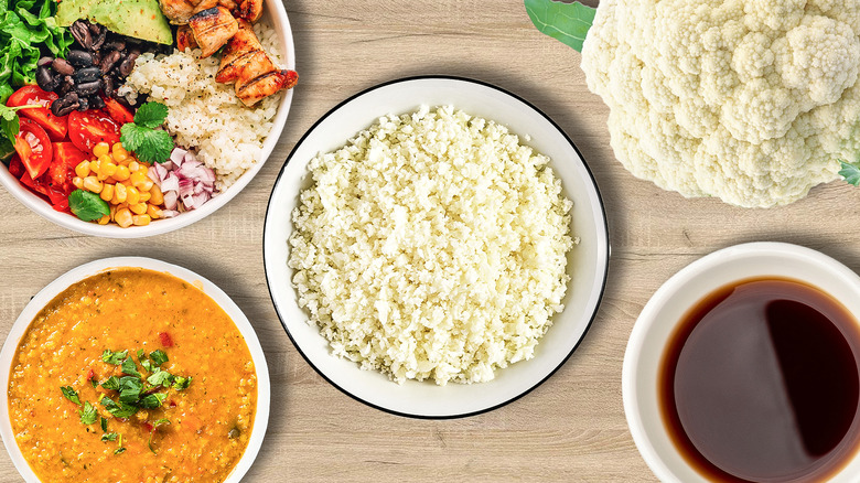 Cauliflower rice in a bowl surrounded by various additions