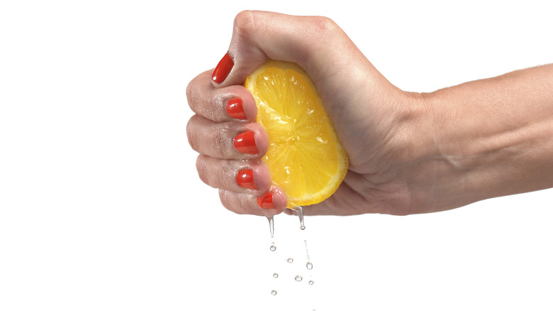 Hand squeezing juice from a lemon