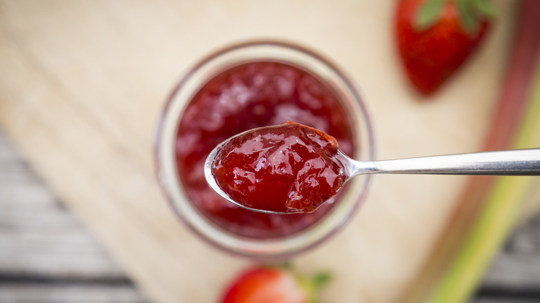 Fresh strawberry jam spooned out of jar