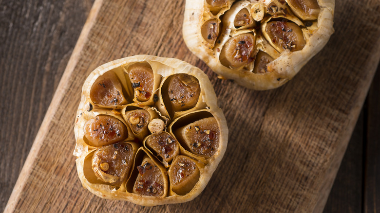 roasted garlic heads on a cutting board