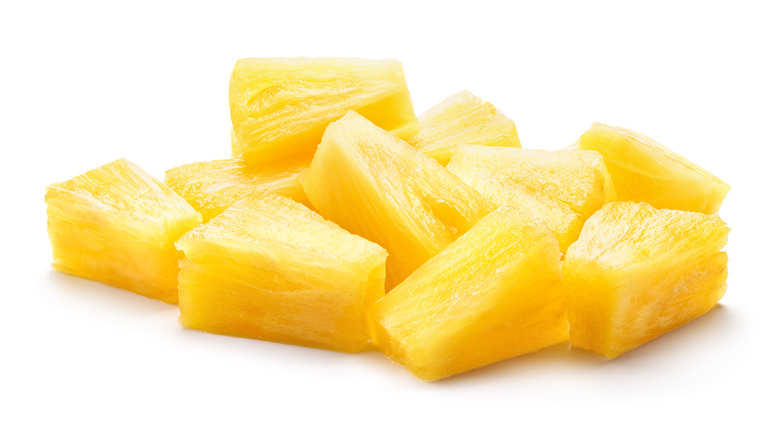 canned pineapple chunks on white background.