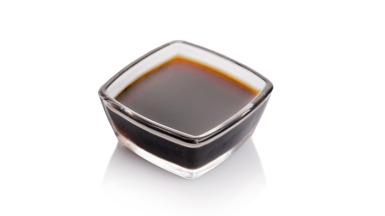 small square glass bowl with dark soy sauce