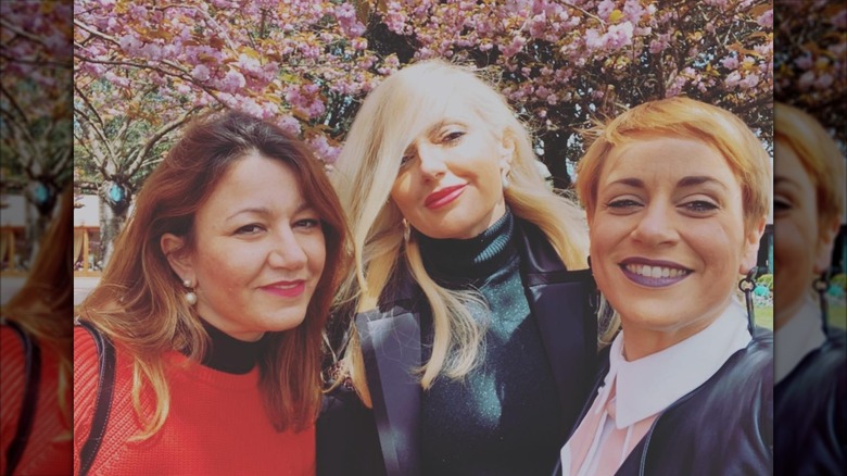 Italian winemakers Marta, Dominga, Enrica Cotarella with a tree in bloom in the back