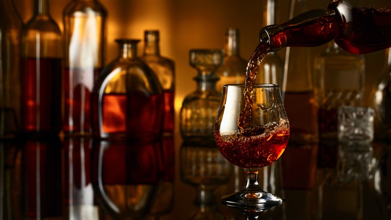 brandy being poured into glass from bottle