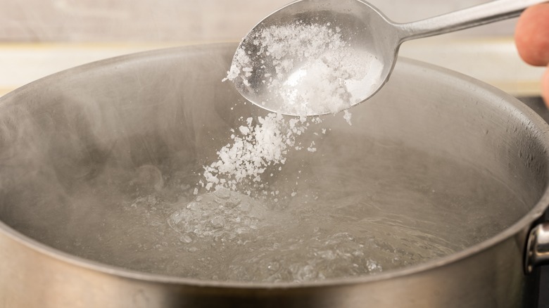 Adding salt to pot with water